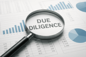 זכוכית מגדלת מעל מסמכים פיננסיים המדגישה בדיקת נכסים עבור עורך דין גירושין כלכלי